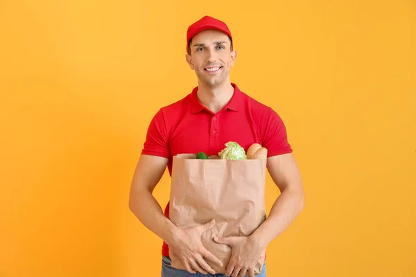 Beau travailleur du service de livraison de nourriture sur fond de couleur — Photo