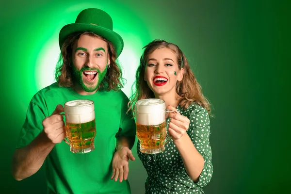 Jong stel met bier op kleur achtergrond. St. Patrick 's Day viering — Stockfoto