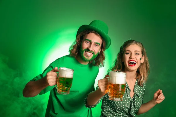 Jong stel met bier op kleur achtergrond. St. Patrick 's Day viering — Stockfoto