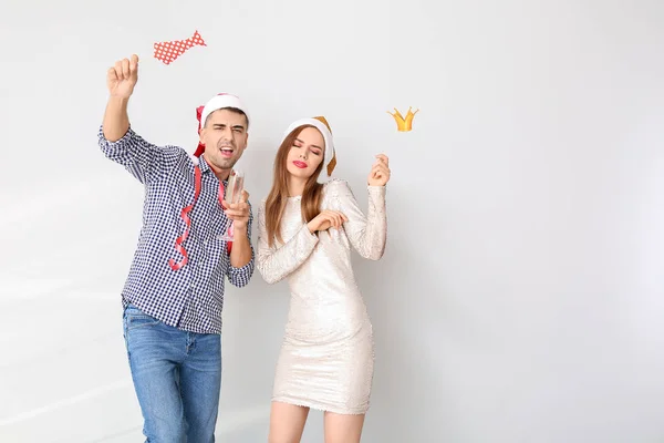 Drunk couple celebrating New Year against light background — Stock Photo, Image