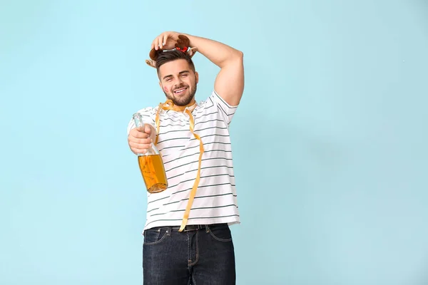 Drunk man with champagne on color background — Stock Photo, Image