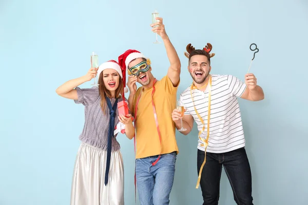 Amigos bêbados celebrando Ano Novo contra fundo de cor — Fotografia de Stock