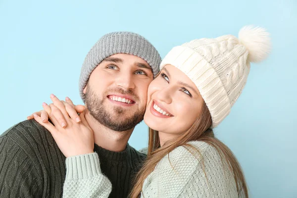 Portrét šťastného páru v zimním oblečení na barevném pozadí — Stock fotografie