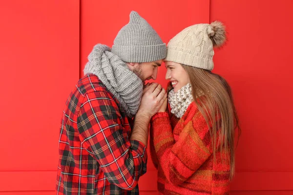 Portrait of happy couple in winter clothes on color background — Stock Photo, Image