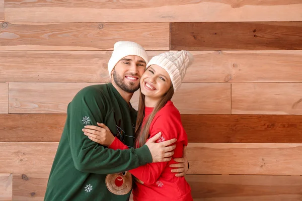 Retrato de pareja feliz en ropa de Navidad sobre fondo de madera — Foto de Stock