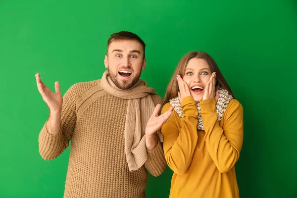 Ritratto di coppia eccitata in abiti invernali su sfondo a colori — Foto Stock