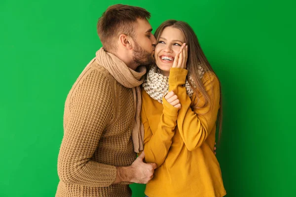 Potret pasangan bahagia dalam pakaian musim dingin di latar belakang warna — Stok Foto