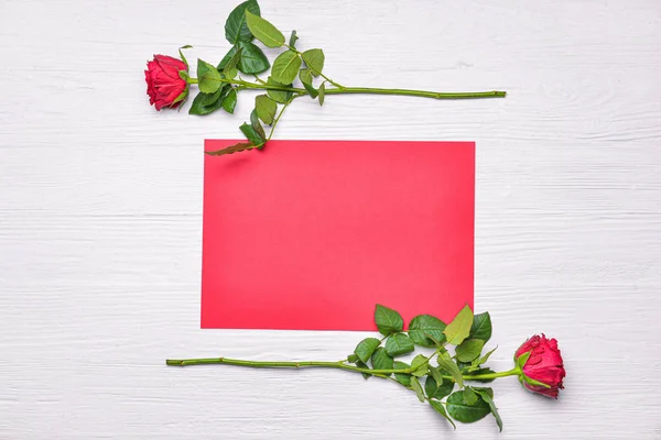 Prachtige rozenbloemen met leeg vel papier op witte achtergrond. Internationale Vrouwendag viering — Stockfoto