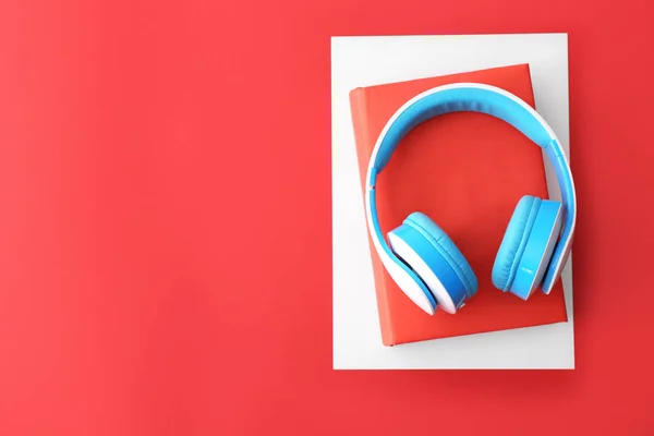 Books and modern headphones on color background. Concept of audiobook — Stock Photo, Image