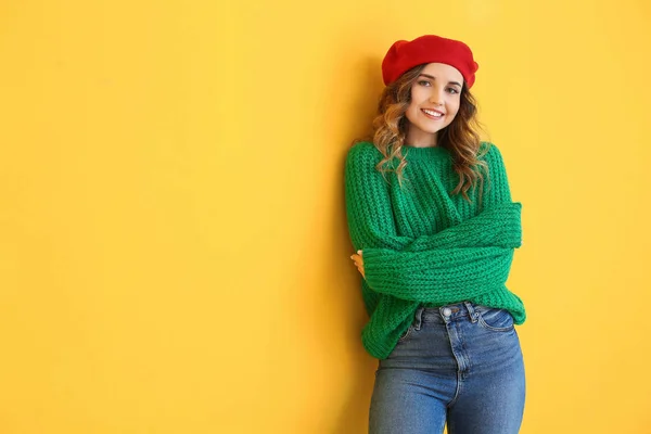 Bella giovane donna in maglione caldo su sfondo di colore — Foto Stock