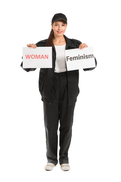 Trabalhadora segurando papéis com texto WOMAN e FEMINISM contra fundo branco — Fotografia de Stock