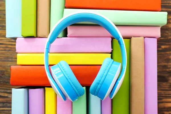 Bücher und moderne Kopfhörer auf Holzgrund. Hörbuchkonzept — Stockfoto