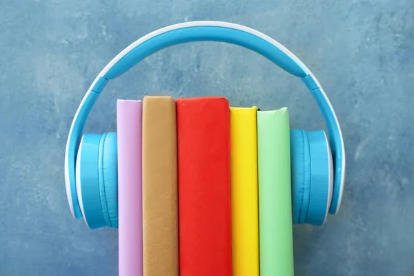 Böcker och moderna hörlurar på färgbakgrund. Begreppet ljudbok — Stockfoto