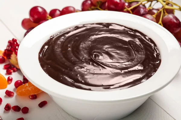 Ízletes csokoládé fondü tál és gyümölcsös asztal — Stock Fotó