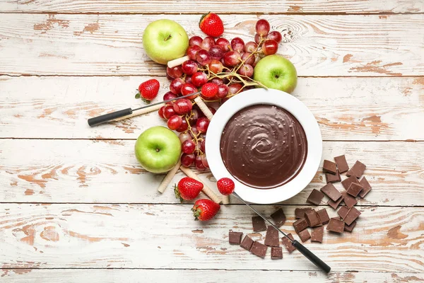 Bowl with tasty chocolate fondue and fruits on table — Stock Photo, Image