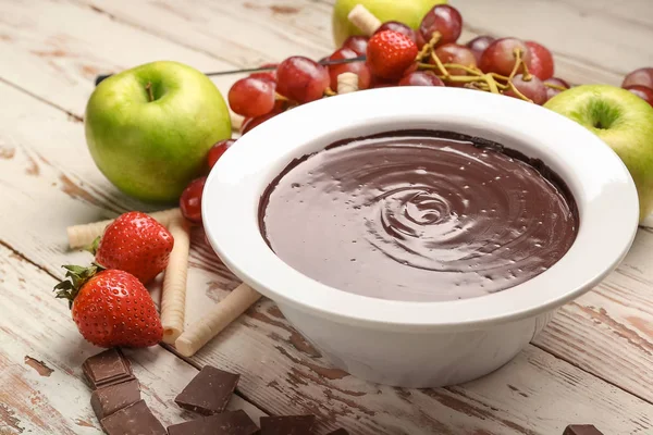 Cuenco con sabrosa fondue de chocolate y frutas en la mesa — Foto de Stock