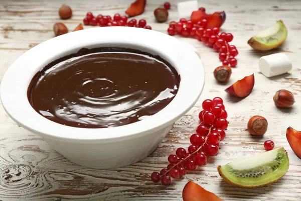 Cuenco con sabrosa fondue de chocolate y frutas en la mesa — Foto de Stock