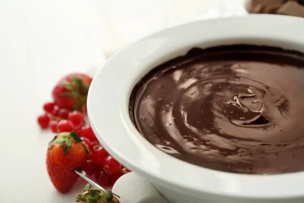 Schaal met smakelijke chocolade fondue en bessen op tafel, close-up — Stockfoto