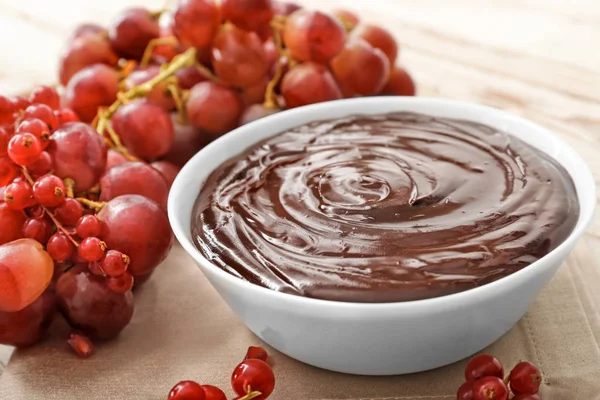 Cuenco con sabrosa fondue de chocolate y bayas en la mesa — Foto de Stock