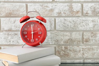 Masada kitaplar olan çalar saat