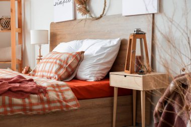 Büyük rahat yataklı ve sonbahar dekorlu şık bir oda.