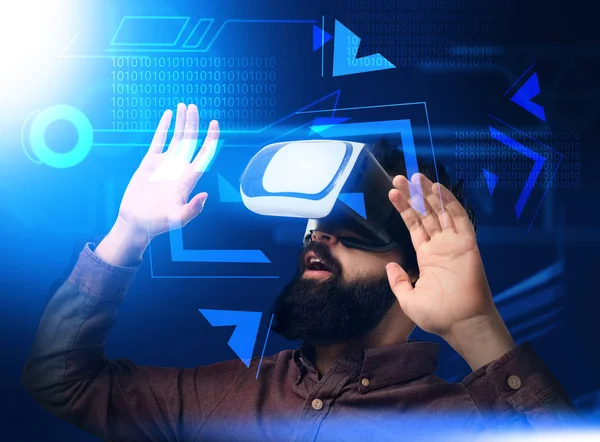 Geschäftsmann mit Virtual-Reality-Brille spielt Videospiel auf dunklem Hintergrund — Stockfoto