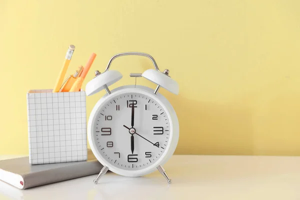 Alarm clock with stationery on table — Stock Photo, Image