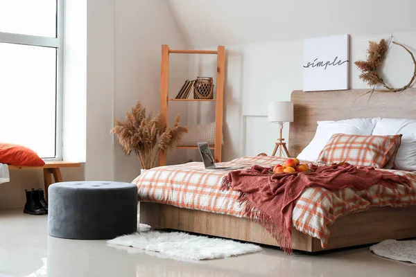 Стильный интерьер комнаты с большой удобной кроватью и осенним декором — стоковое фото