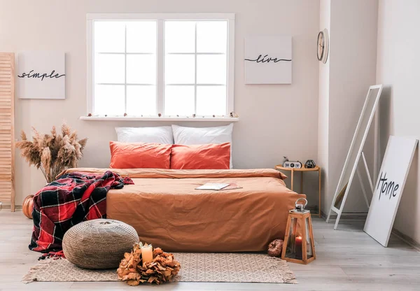 Stylový interiér pokoje s velkou pohodlnou postelí a podzimní výzdobou — Stock fotografie