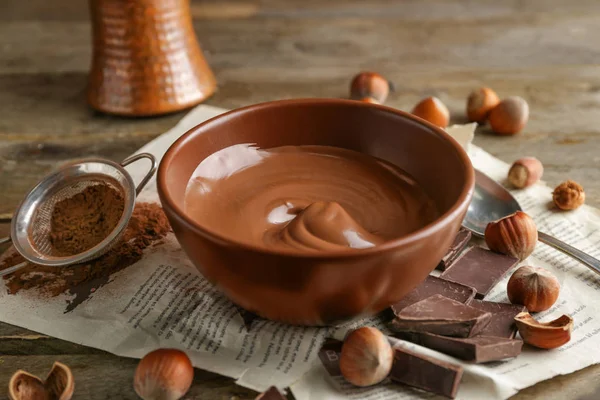 Mangkuk dengan pasta coklat lezat dan hazelnut di atas meja — Stok Foto