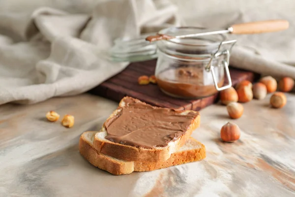 Fresh bread with tasty chocolate paste on table — Stock Photo, Image