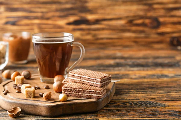 Deliciosos gofres de chocolate con avellanas y café sobre mesa de madera — Foto de Stock