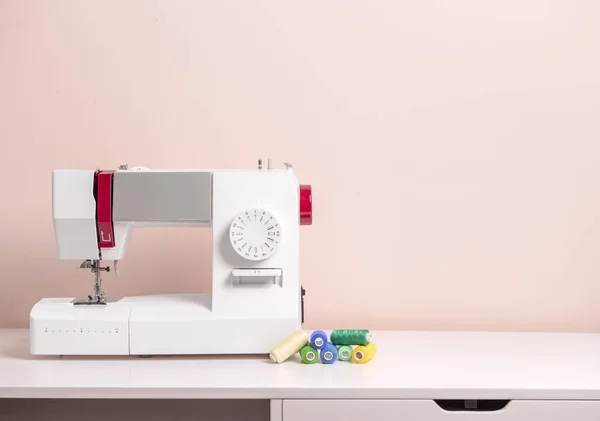Швейная машина с припасами на столе — стоковое фото