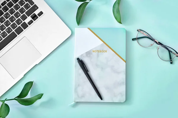 Stylowy notatnik z laptopem i okularami na kolorowym tle — Zdjęcie stockowe