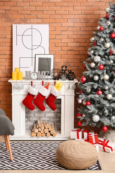 Christmas socks with gifts hanging on fireplace in interior of room — Stock Photo, Image