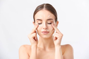 Güzel kadın beyaz arka plan karşı yüzünü masaj