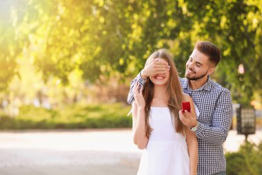 Genç adam dışarıda sevgilisine evlenme teklif ediyor.