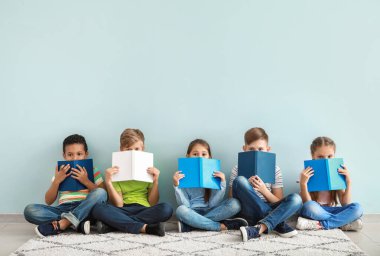 Kitap renk arka plan üzerinde küçük sevimli çocukla