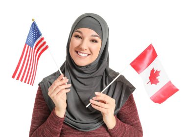 Beyaz arka planda Usa ve Kanada bayrakları olan güzel Müslüman kadın.