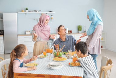 Müslüman bir aile evde yemek yiyor.