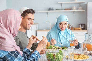 Müslüman bir aile evde yemek yiyor.