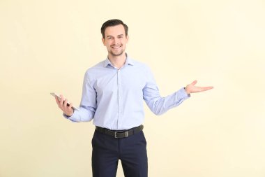 Tablet bilgisayarlı erkek emlakçı arka planda bir şey gösteriyor.