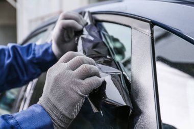 Erkek işçi araba camını boyuyor, yakın plan.