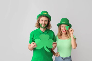 Hafif arka planda yoncalı genç bir çift. Aziz Patrick Günü kutlaması