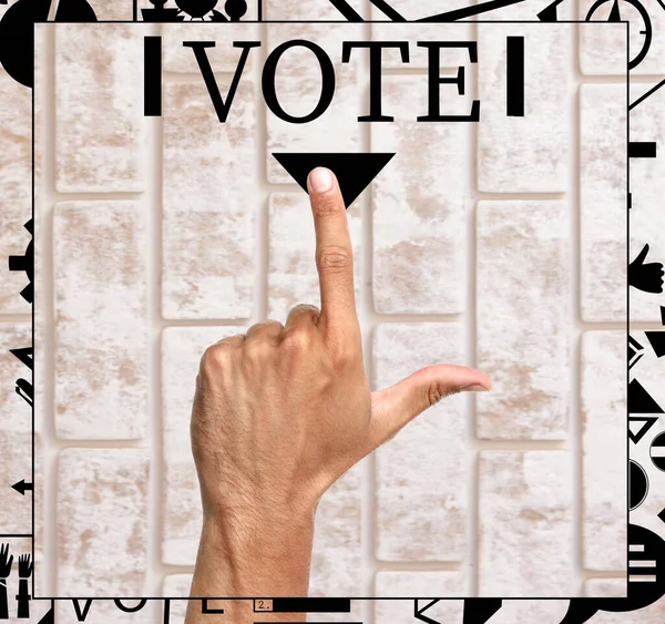 Mano masculina apuntando a la palabra VOTE sobre fondo de ladrillo —  Fotos de Stock