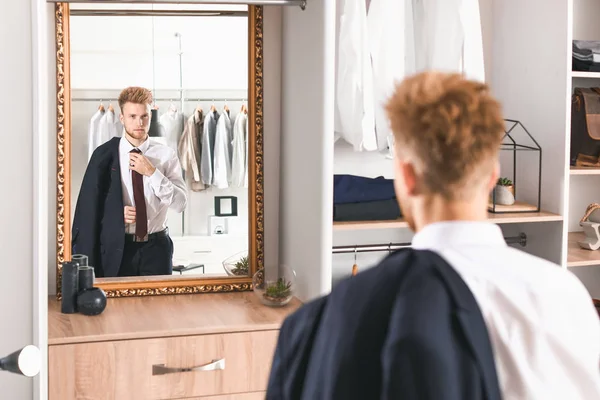 Hombre guapo probándose ropa elegante en el vestidor —  Fotos de Stock