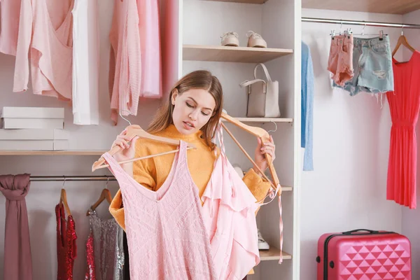 Mooie jonge vrouw kiezen kleding uit grote garderobe — Stockfoto