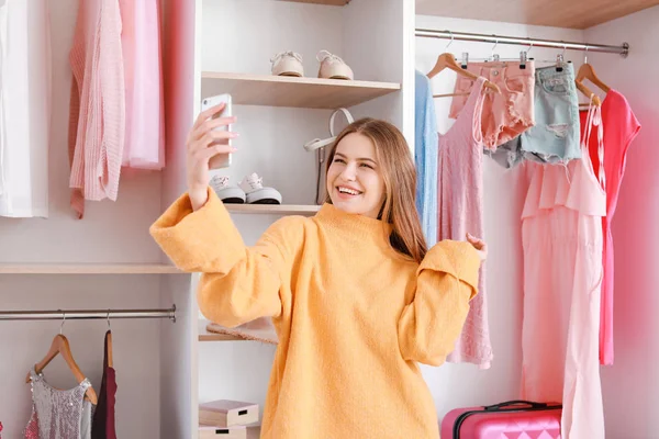 Mooie jonge vrouw het nemen van selfie in de buurt van grote garderobe — Stockfoto