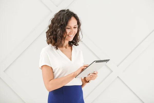 Porträt der schönen Geschäftsfrau mit Tablet-Computer auf grauem Hintergrund — Stockfoto