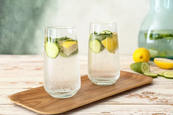 Glasses of cold cucumber water on white table — Stock Photo, Image